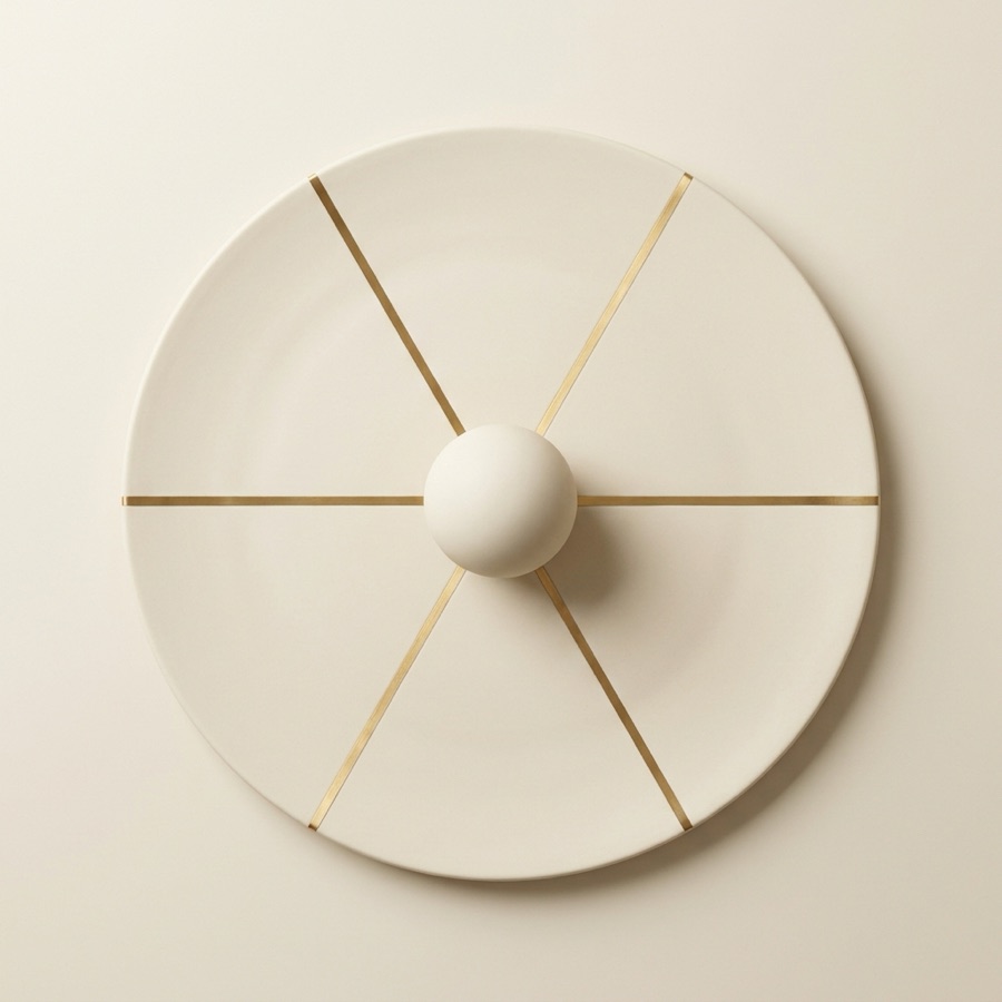 Round porcelain disc with six gold routes meeting at a sphere in the centre