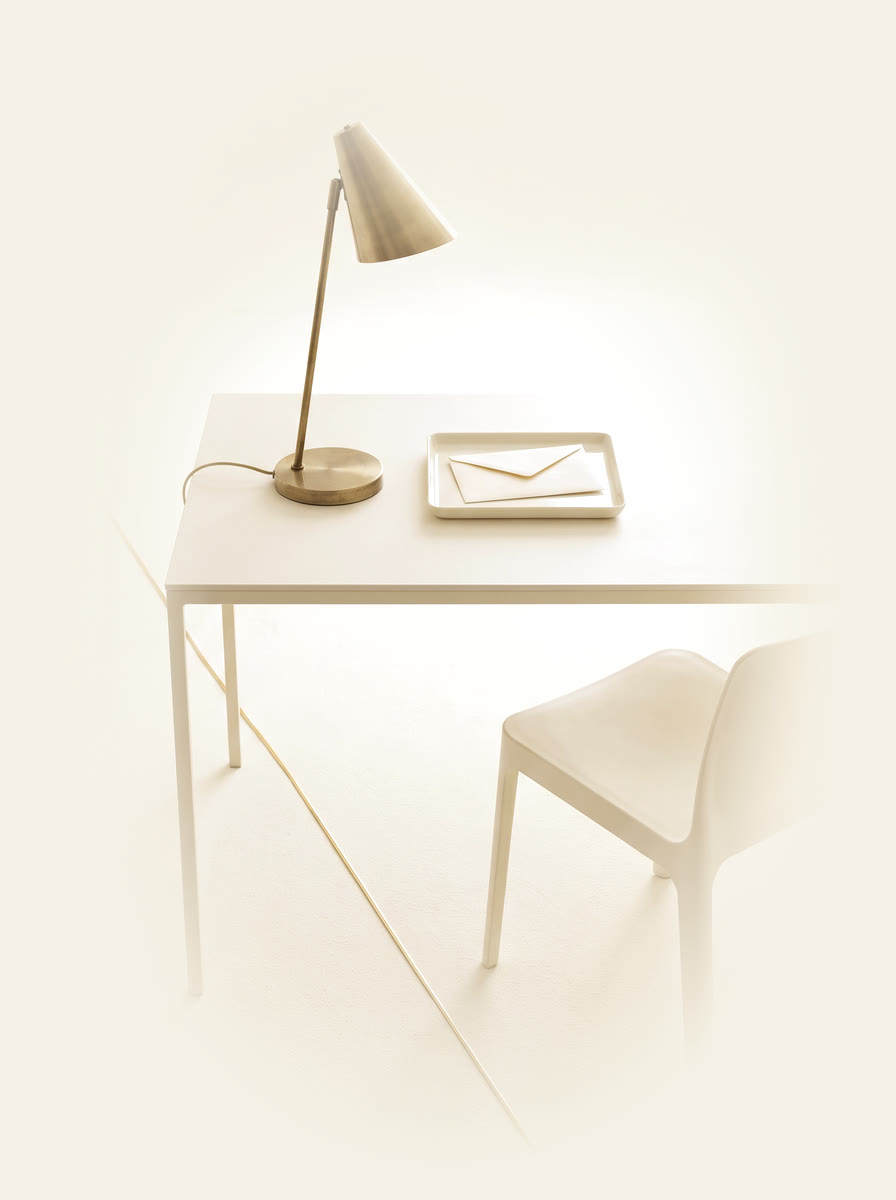 A sealed envelope on a tray with one chair pulled up